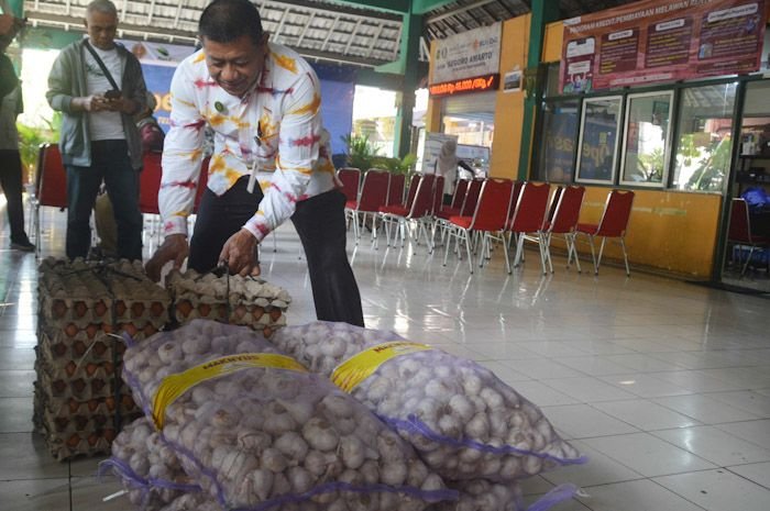 Petugas dari Dinas Perdagangan Kota Yogayakarta menata telur ayam ras dan bawang putih yang menjadi komoditas dalam operasi pasar.