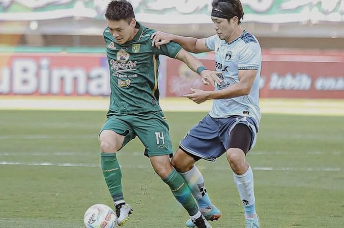 Pemain Persebaya Sho Yamamoto (kiri) berebut bola dengan pemain Persita Sin Yeong Bae