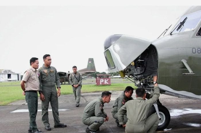 Petugas mempersiapkan pesawat yang akan digunakan untuk penyemaian garam di udara guna mencegah cuaca ekstrem di Lanud Halim Perdanakusuma, Jakarta Timur