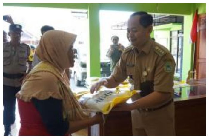 Penyerahan beras kepada warga yang membeli di pasar murah beras SPHP